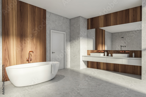 Modern Bathroom interior in new luxury home. Stylish hotel room. Open space area. Concrete wooden walls and floor. Bathtub and double sink. White door.