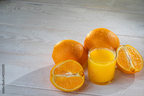 Orange juce and oranges are standing on the white background photo