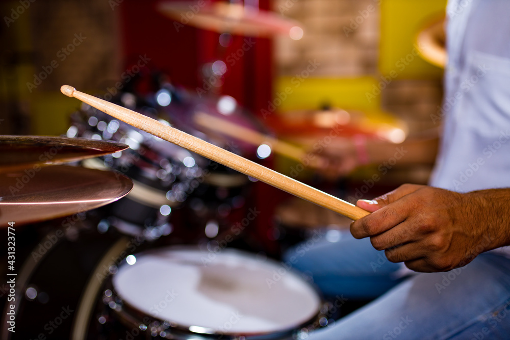 Naklejka premium Attractive Teenage Drummer with Drumsticks in recording studio