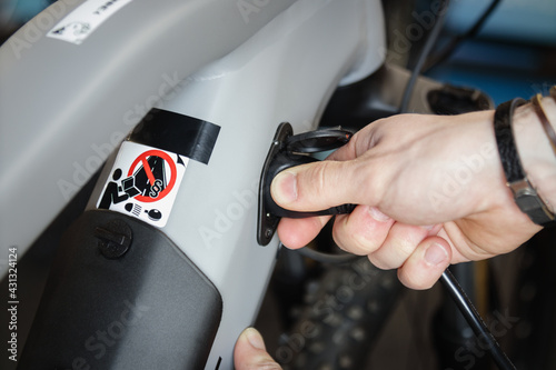 Charging electric bicycle. Unplugging charger from an ebike. Environmentally friendly transport. 