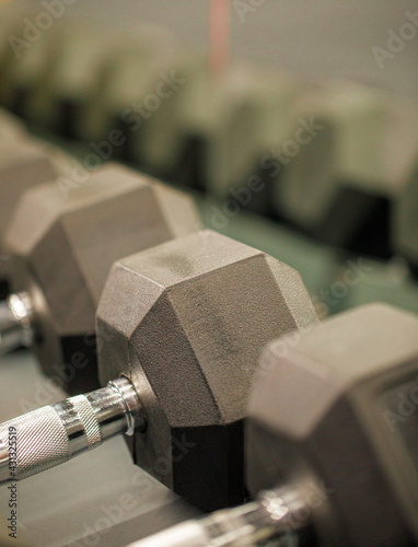 Rows of black dumbbells in the workout gym in high resolution and urban style.