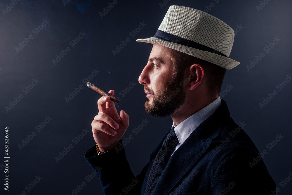 Portrait of an attractive business man with a cigar in black background studio Portrait of an attractive business man with a cigar in black background studio