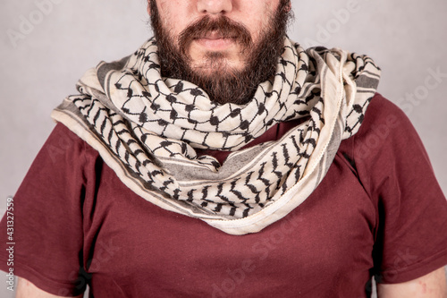 a Young Revolutionary Palestinian Man wearing Traditional keffiyeh or kufiya arround the Neck  photo