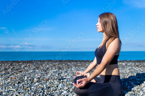 doing yoga exercises outdoors at the beach pier in stone beach photo