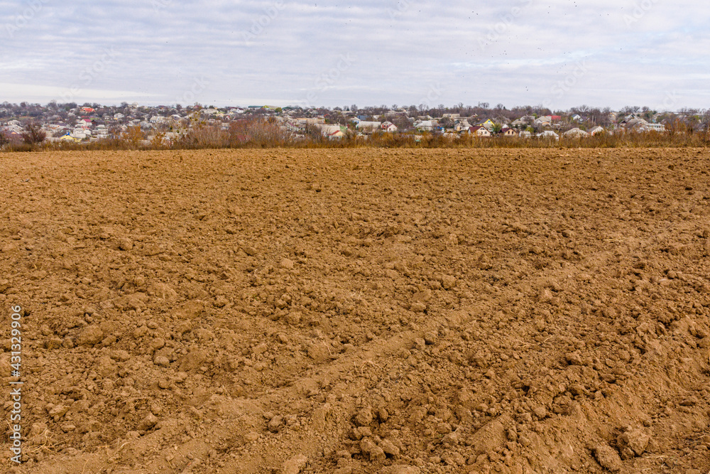 Plowed field at autumn. City Uman on a background. Ukraine