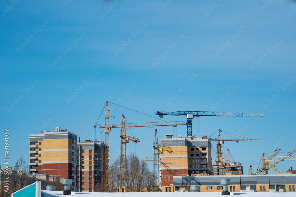 construction tower cranes build monolithic frame houses and brick houses against the sky in the city construction tower cranes build monolithic frame houses and brick houses against the sky in the city