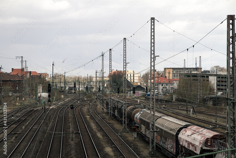 train railroad tracks with parking wagons and electric power lines, symbol for urban vibes and industry - obrazy, fototapety, plakaty 