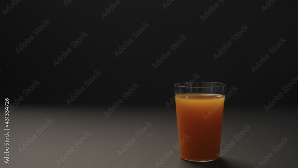 mango juice in tumbler glass on black paper background with copy space mango juice in tumbler glass on black paper background with copy space