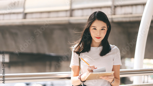 Portrait of young adult business working asian beauty woman holding a digital tablet.