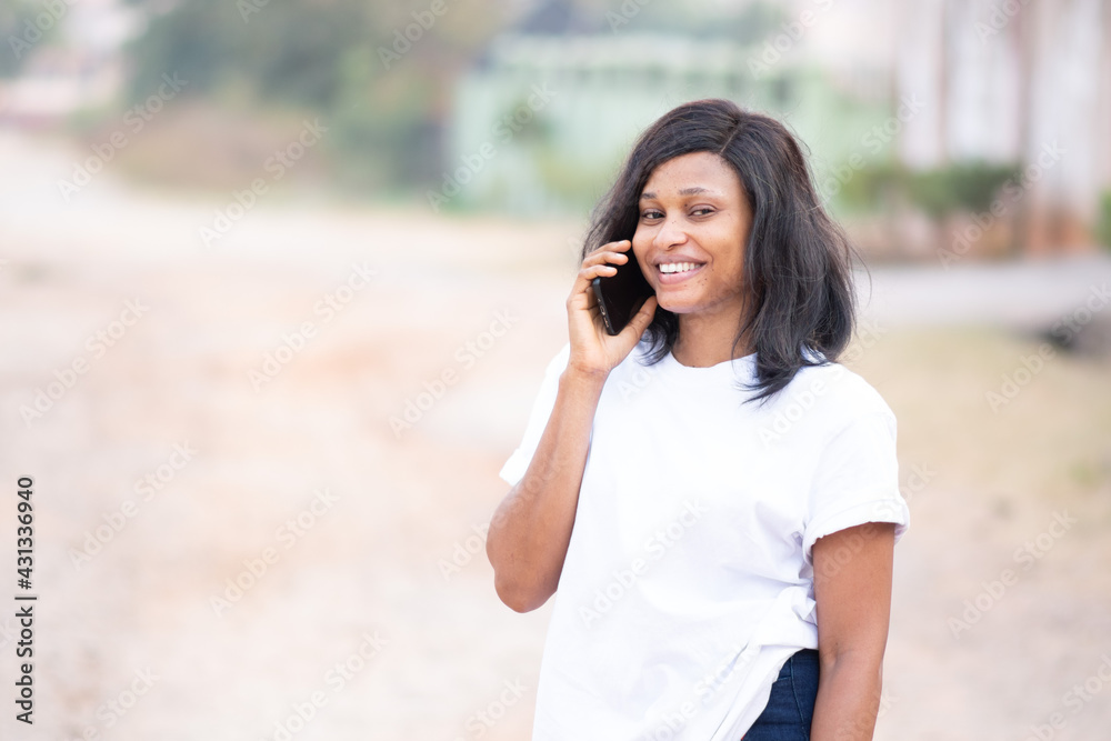 beautiful young african lady smiling while calling someone beautiful young african lady smiling while calling someone