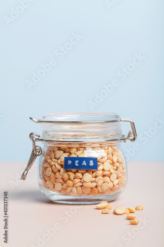 yellow peas in glass jar on blue and white background. healthcare lifestyle and organic food concept.
