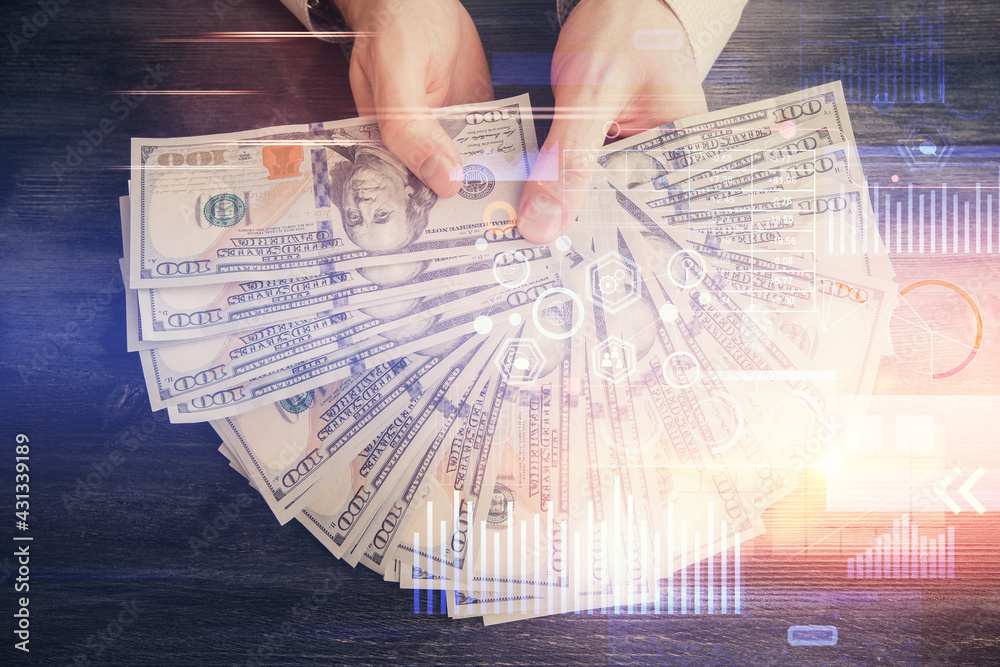 Multi exposure of technology drawing hologram and us dollars bills and man hands. Data concept Multi exposure of technology drawing hologram and us dollars bills and man hands. Data concept