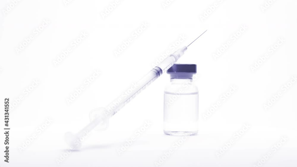 small glass bottle and syringe with the vaccine or medical supplies on a white background (looping) small glass bottle and syringe with the vaccine or medical supplies on a white background (looping)