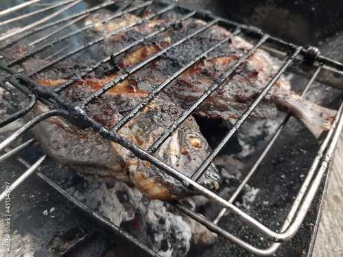grilled fish on wood charcoal, and covered with soy sauce to produce a smoky aroma, a photo suitable for seafood sales
