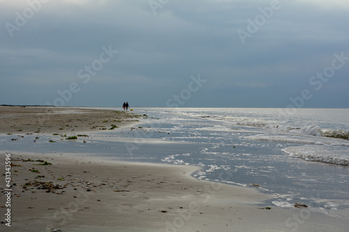 Fototapeta Naklejka Na Ścianę i Meble -  Sand beach with waves on the North Sea coast with people