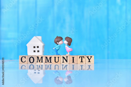 Community - word from wooden blocks with letters, group of people community concept, on blue wooden wall background