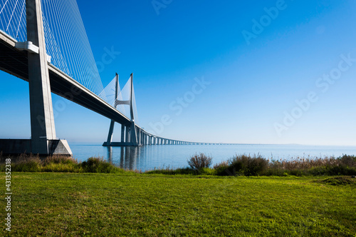 Fototapeta Naklejka Na Ścianę i Meble -  Vasco da Gama Brücke in Lissabon. Blick vom Ufer aus zur blauen Stunde