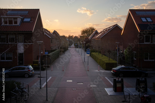 Sunset over a Dutch Vinex neighbourhood with a bicycle path as central road
