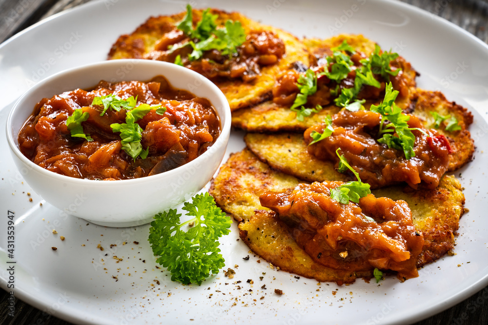 Potato pancakes with vegetable stew on wooden table Potato pancakes with vegetable stew on wooden table