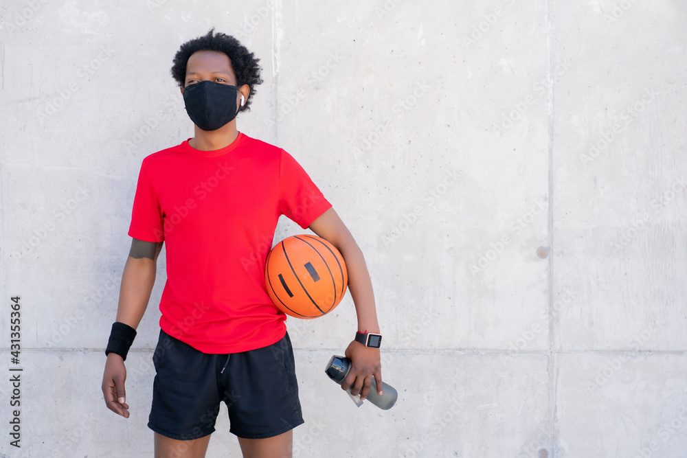 Fototapeta premium Afro athletic man holding basketball ball.