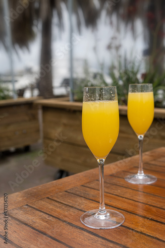 Two glasses of Mimosa outdoor sitting restaurant, nobody in it
