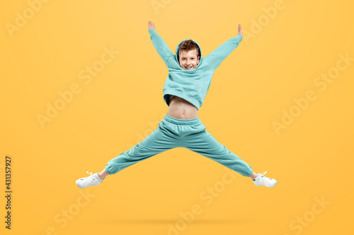 Cute stylish boy in a blue suit on a yellow background. Studio portrait of a child  modern design  trendy background.