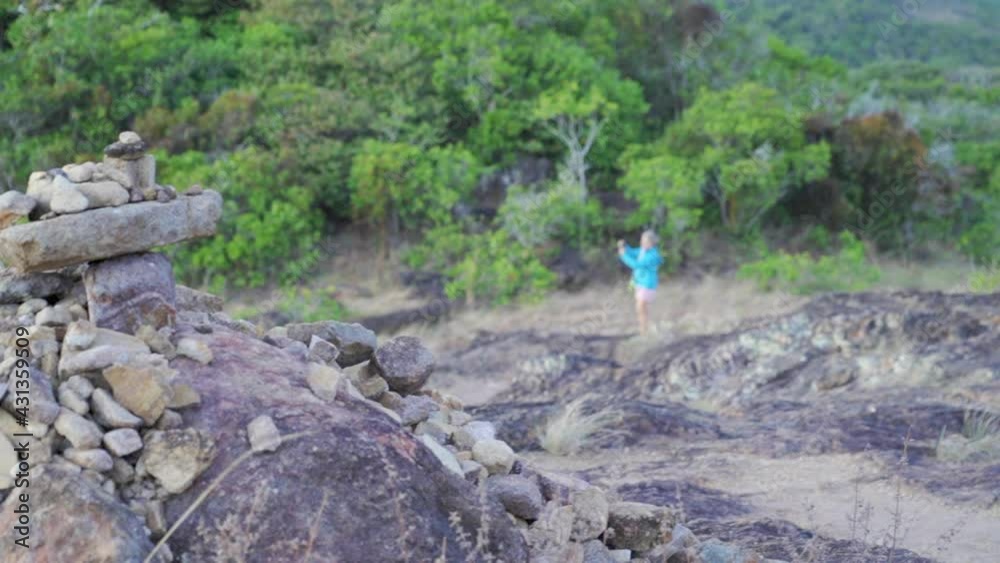 Close-Up Pan Of Rocks With A Focus Transition To A Woman In The Background Taking Photographs Of Nature, With Lush Green Trees - Cape York, Australia Close-Up Pan Of Rocks With A Focus Transition To A Woman In The Background Taking Photographs Of Nature, With Lush Green Trees - Cape York, Australia