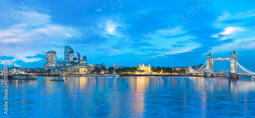 Panorama of the Tower Bridge and Tower of London on Thames river at twilight blue hour with thunder and lightning - London England
