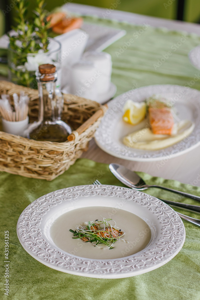 Cheese soup with salmon in green interior background Cheese soup with salmon in green interior background
