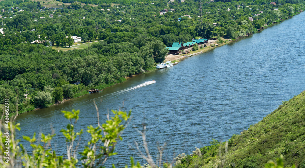 Obraz premium Tourist recreation center on the banks of the river. Spring water. Forest by the river, sunny summer day