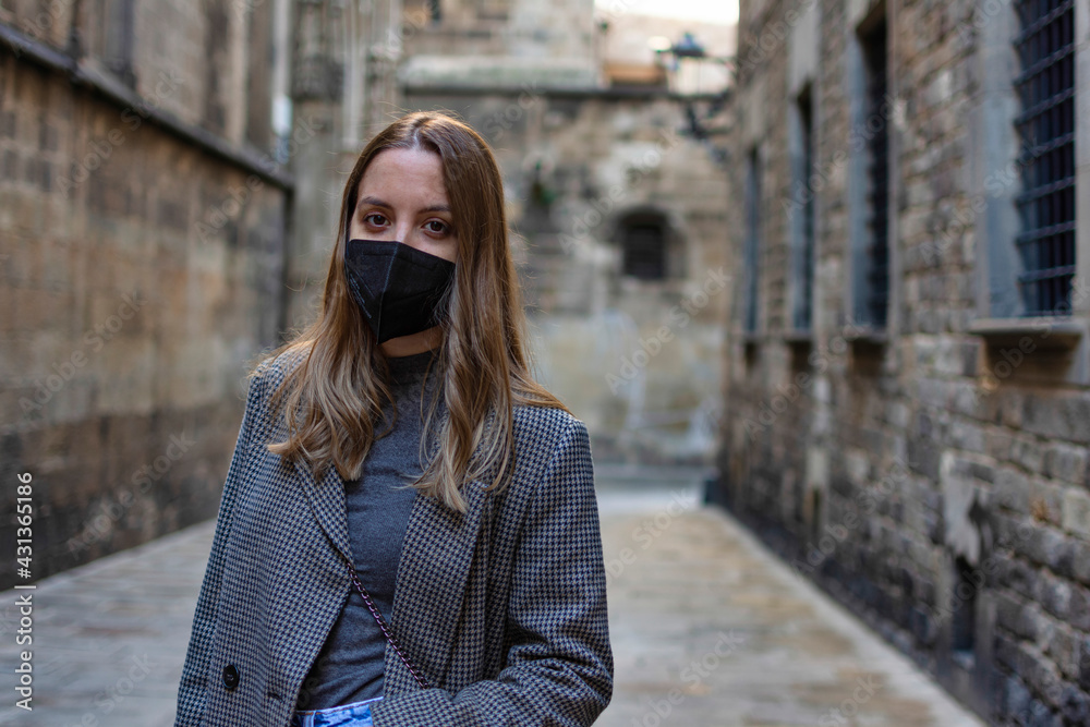 Obraz premium Young girl with casual style mask posing in the old town