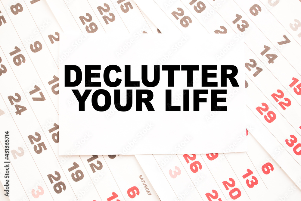 Notepad with text DECLUTTER YOUR LIFE on the office desk with stationery. A blank notepad for entering a copy or text. business