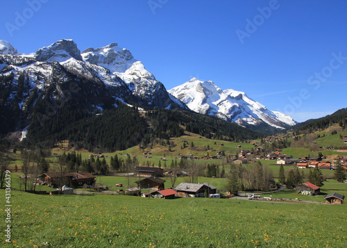 Village Gsteig bei Gstaad and snow covered mountains on a spring day. photo