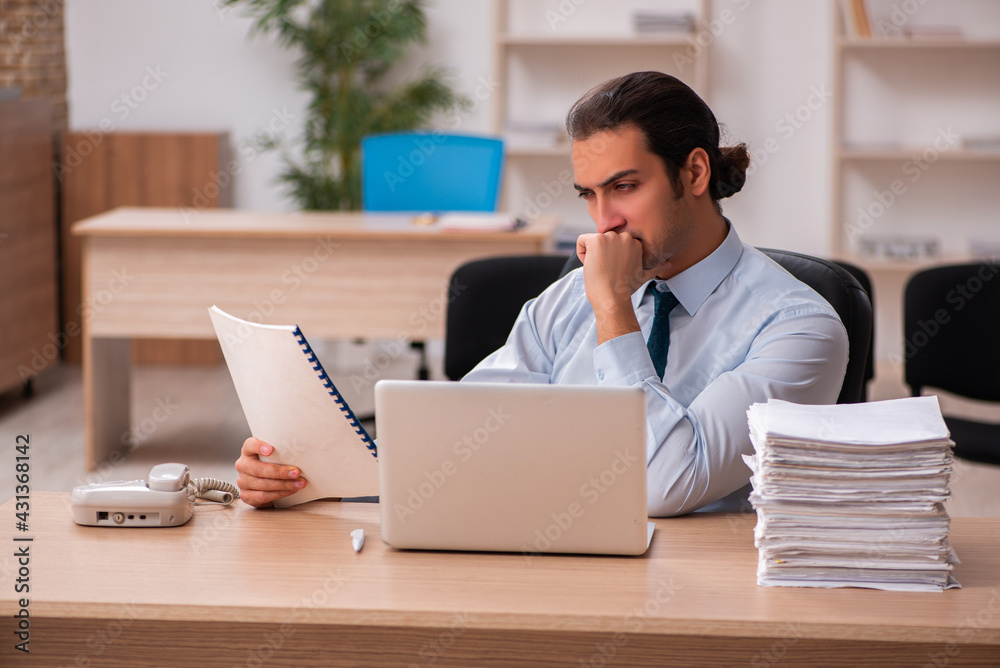 Young male employee unhappy with excessive work Young male employee unhappy with excessive work