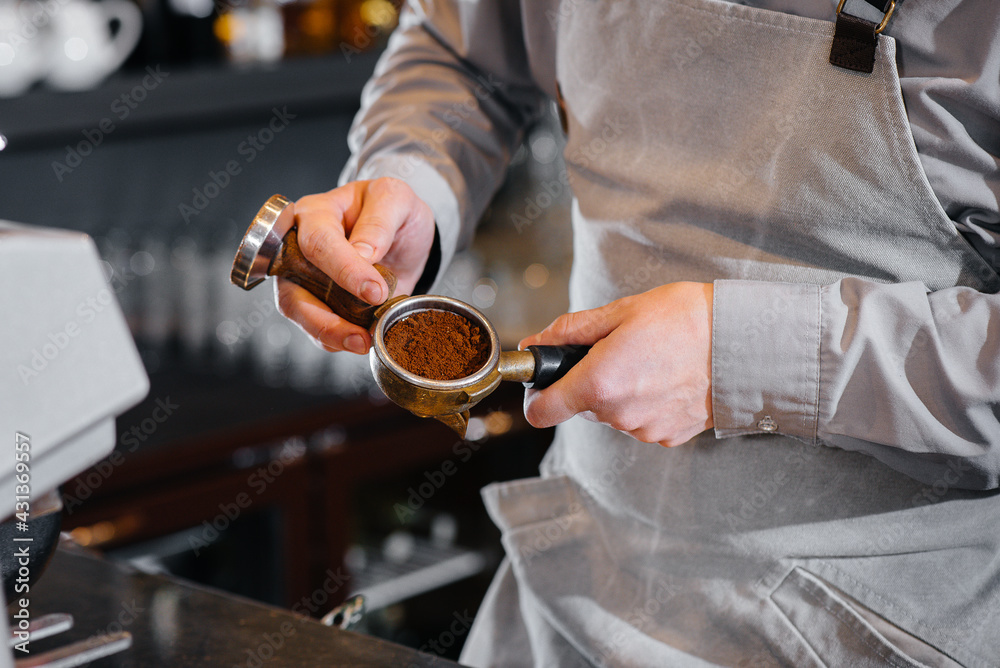 The barista prepares delicious coffee in a modern coffee shop close-up.