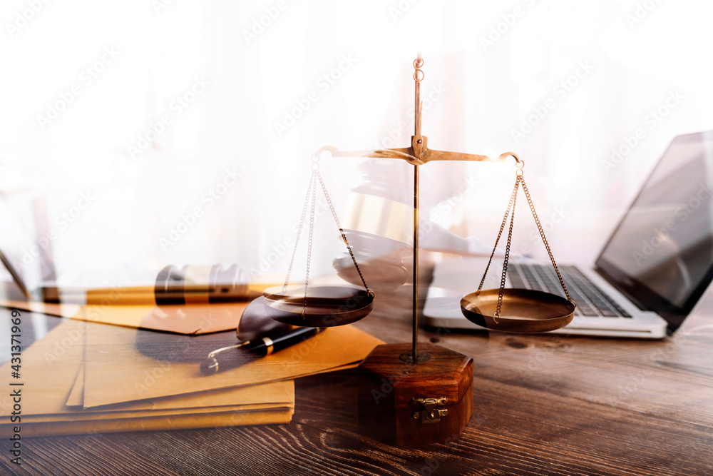Business and lawyers discussing contract papers with brass scale on desk in office. Law, legal services, advice, justice and law concept picture with film grain effect Business and lawyers discussing contract papers with brass scale on desk in office. Law, legal services, advice, justice and law concept picture with film grain effect