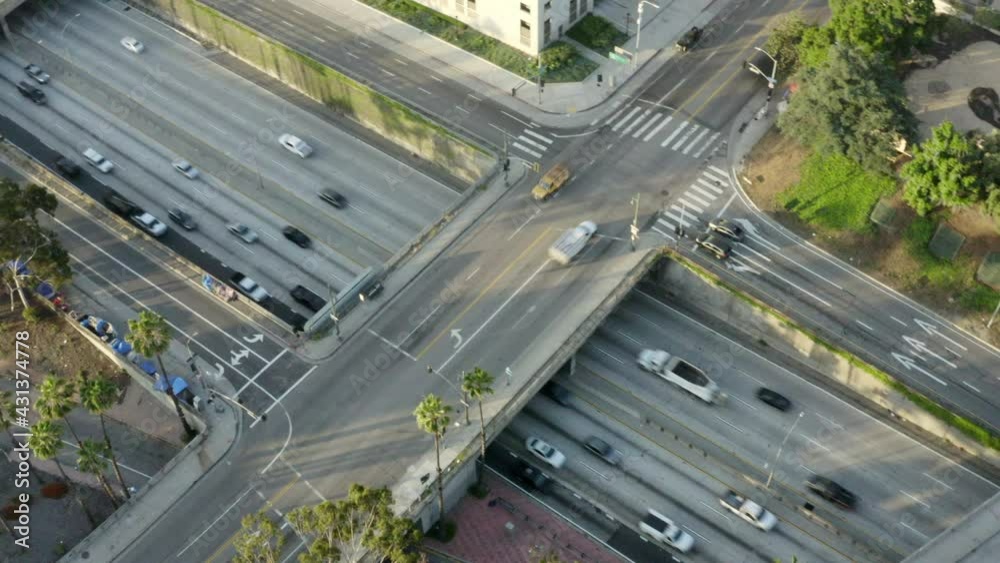 Aerial Slow Motion Panning Of The Santa Ana Freeway In Downtown La With Surrounding Buildings Under A Bright Sky And The City Suburbs Stretching Into The Distant Hazy Horizon - Los Angeles, California Aerial Slow Motion Panning Of The Santa Ana Freeway In Downtown La With Surrounding Buildings Under A Bright Sky And The City Suburbs Stretching Into The Distant Hazy Horizon - Los Angeles, California
