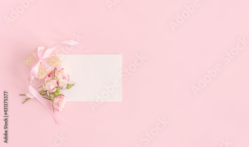 Elegant flowers and greeting card on pink background. Flat lay. Birthday, wedding, spring or summer holidays concept. © Kira