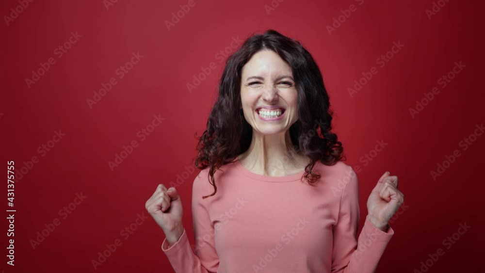 Excited brunette female happy, cheering in excitement, overjoyed show thumb up gesture isolated over red studio background. Portrait of cheerful amazed millennial curly woman winner celebrate say yes Excited brunette female happy, cheering in excitement, overjoyed show thumb up gesture isolated over red studio background. Portrait of cheerful amazed millennial curly woman winner celebrate say yes