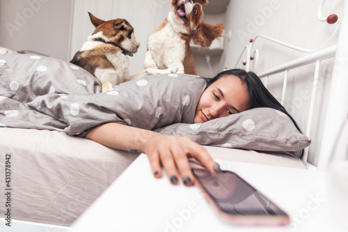 Photography A young girl wakes up in her bed and turns off the alarm