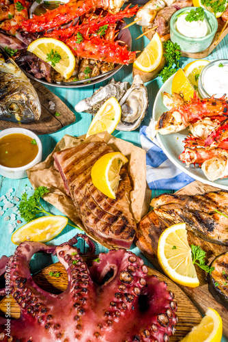 Assortment various barbecue Mediterranean grill food - fish, octopus, shrimp, crab, seafood, mussels, summer diet bbq party fest, with kebab, sauces, light blue sunny wooden background