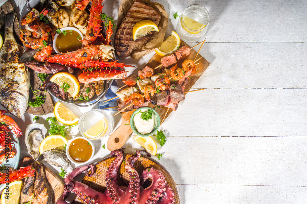 Assortment various barbecue Mediterranean grill food - fish, octopus, shrimp, crab, seafood, mussels, summer diet bbq party fest, with kebab, sauces, white wooden background, above copy space