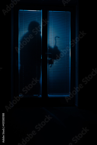 Silhouette eines Einbrechers der Nachts in eine Wohnung einsteigt