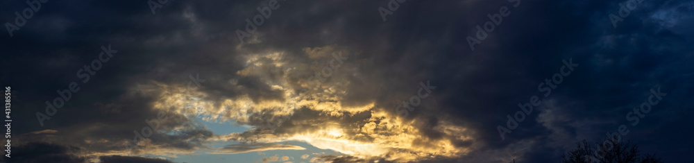Panorama of cloudy sky with sun rays.