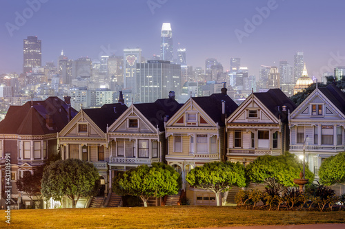 Dusk Over The Painted Ladies of San Francisco. Iconic Victorian Houses and San Francisco Skyline in Alamo Square, San Francisco, California, USA.