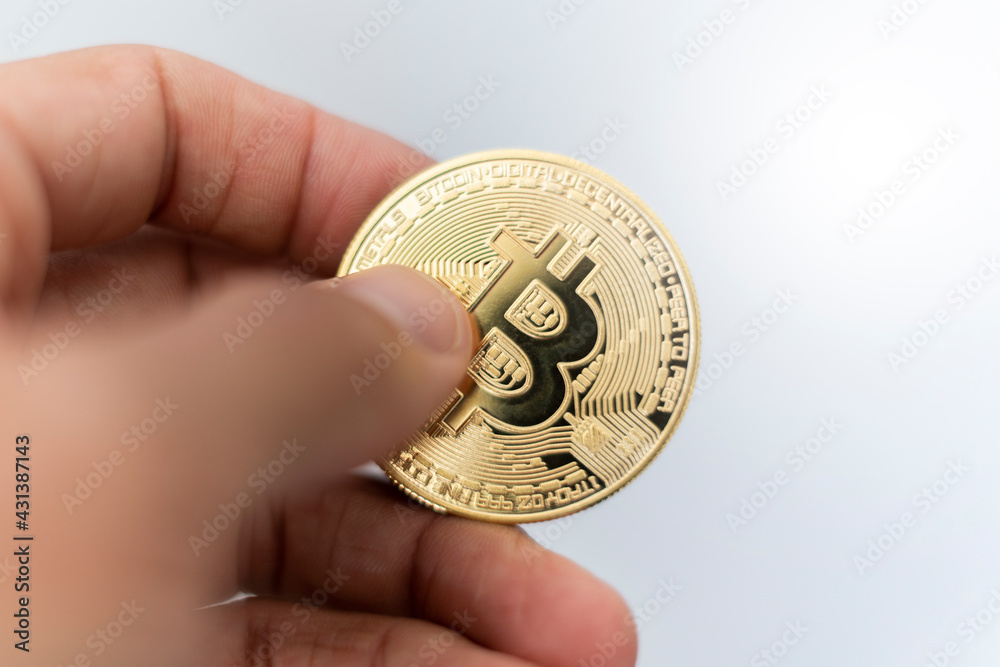 Bitcoin. Hand holding gold coin with BTC symbol. Person investing in virtual assets like cryptocurrency concept background Bitcoin. Hand holding gold coin with BTC symbol. Person investing in virtual assets like cryptocurrency concept background