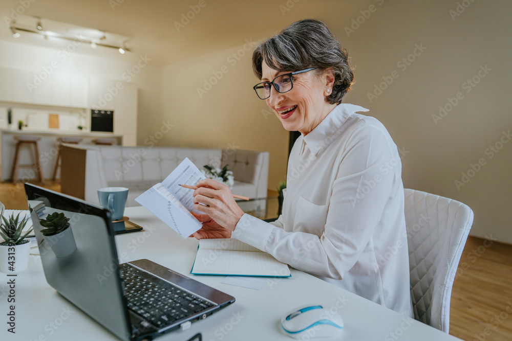 Mature woman learning foreign language using a laptop at home Mature woman learning foreign language using a laptop at home