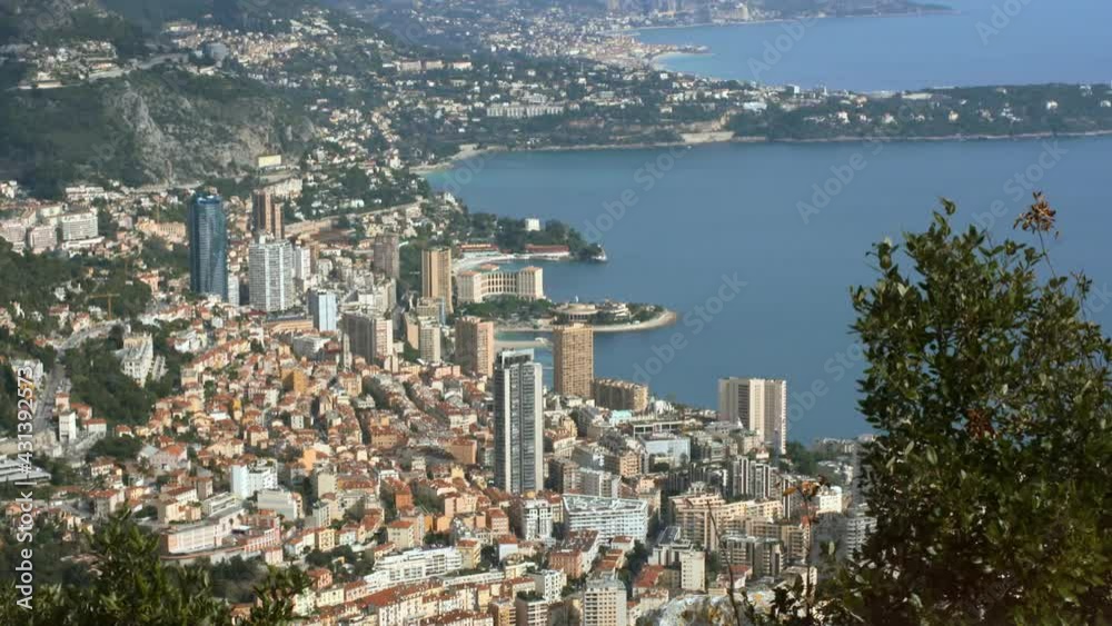 Panning, From A High Angle View, The Dense Coastline Of Monte Carlo With Apartment Buildings Lining The Shore, And Rolling Hills And Trees In The Background Panning, From A High Angle View, The Dense Coastline Of Monte Carlo With Apartment Buildings Lining The Shore, And Rolling Hills And Trees In The Background