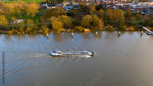 Barge navigating on the Scheldt river  near Dendermonde  Belgium. Aerial view at sunset