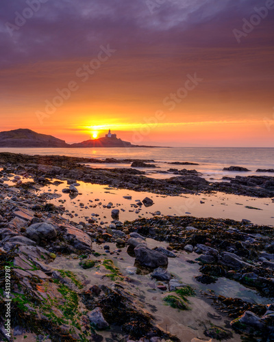 Sunrise on the Mumbles Light House from Bracelet Bay  Gower Peninsula  Wales  UK